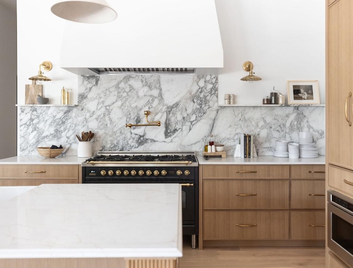 Full-height marble slab backsplash with oak cabinetry and brass pot filler kitchen, Upland California