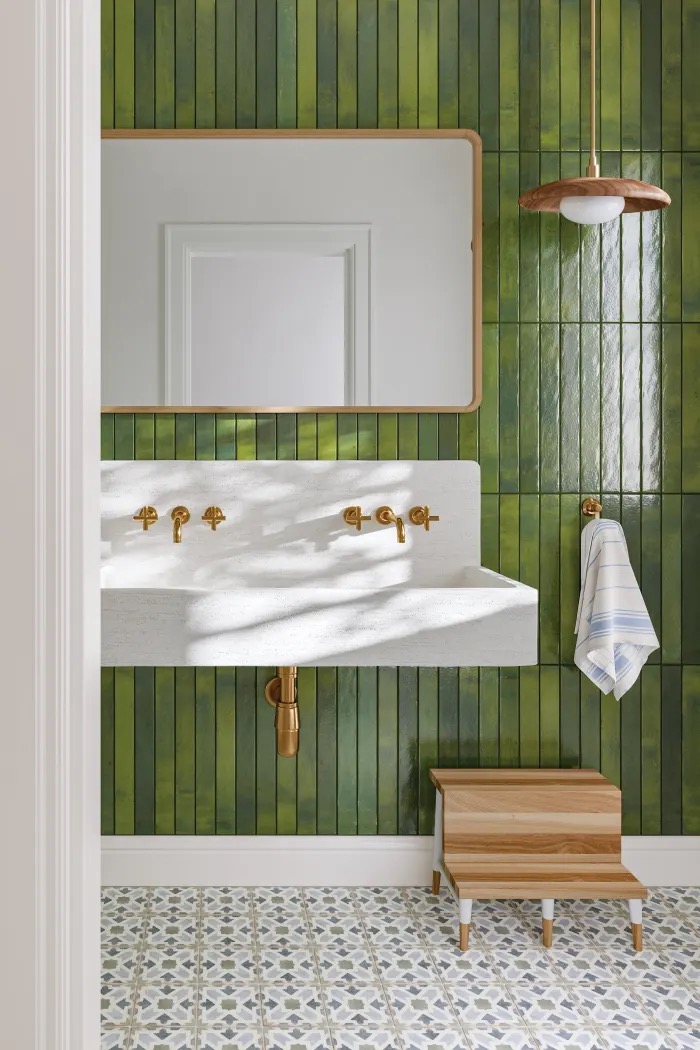 Emerald vertical gloss tile wall with concrete trough sink and patterned cement floor